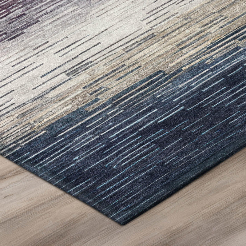 Corner of striped area rug with multicolor horizontal bands in pink, gold, gray, and navy
