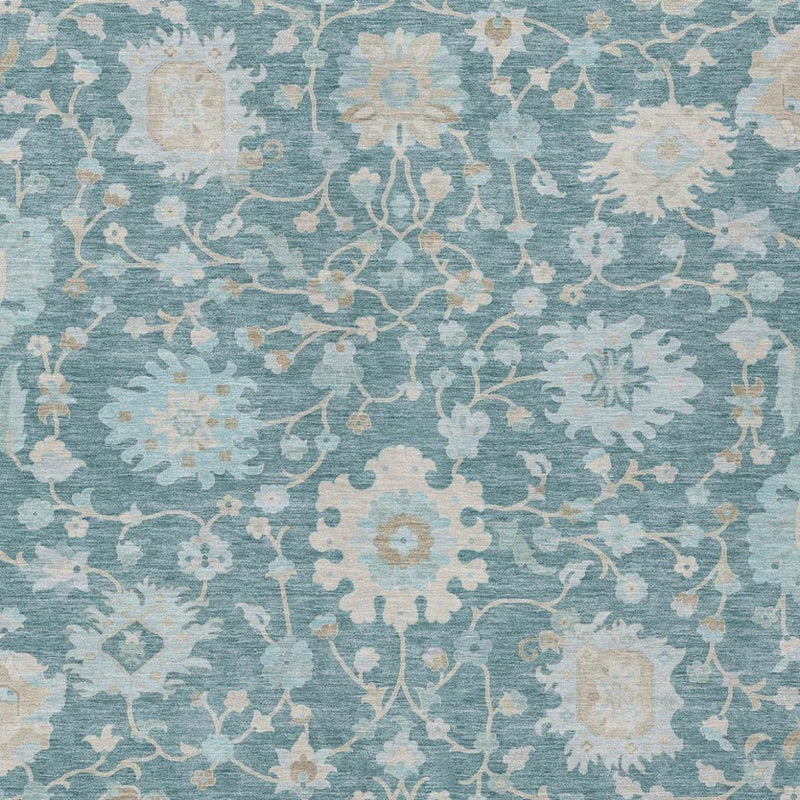 Close-up of teal blue floral area rug with cream and silver ornate motifs