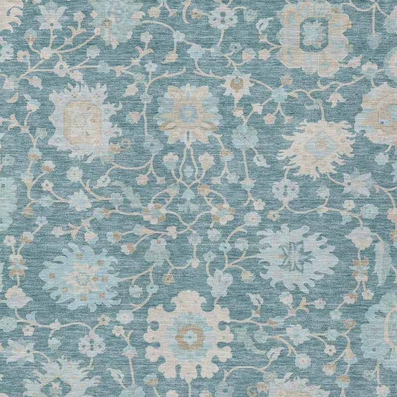 Teal blue floral area rug texture close-up with faded cream pattern