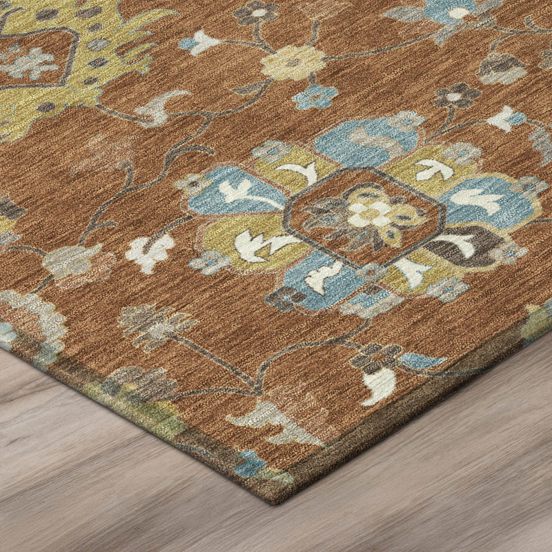 Close-up of rust-brown round rug with distressed floral motifs in blue, cream, and yellow