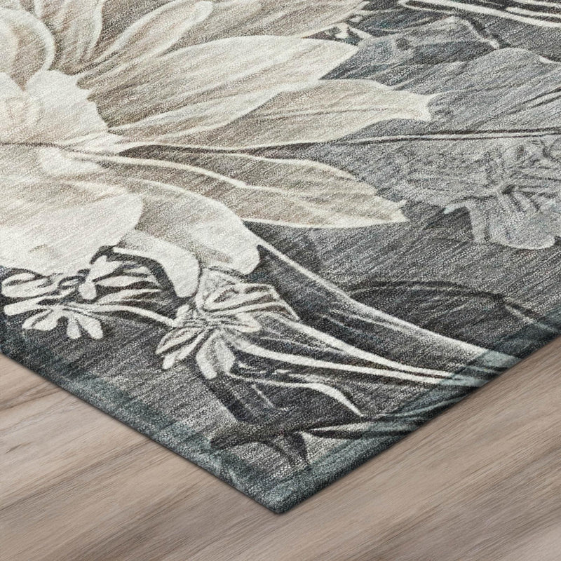 Corner detail of gray area rug with light floral print and dark vine background