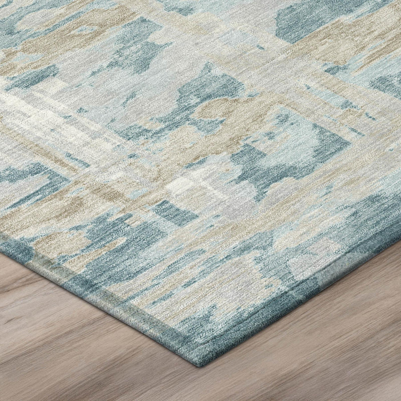 Corner view of teal blue and silver abstract area rug with low-pile textured weave