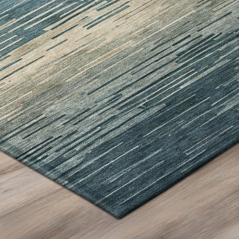 Edge corner of teal and silver area rug showing textured stripe weave and binding