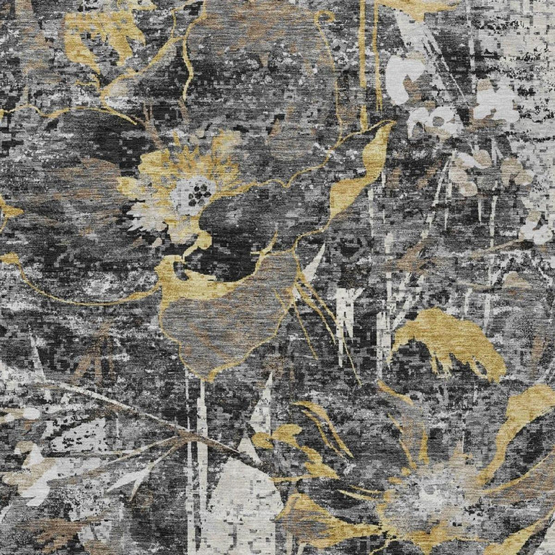 Textured close-up of black-and-graphite rug with gold and ivory distressed shapes