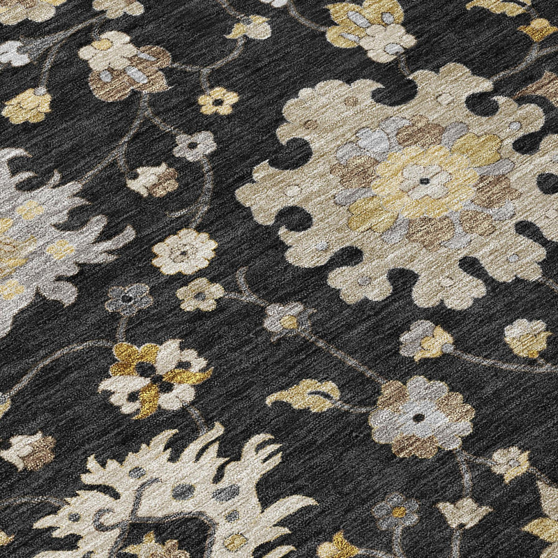 Close-up of black floral rug with cream, gray, and gold flower motifs
