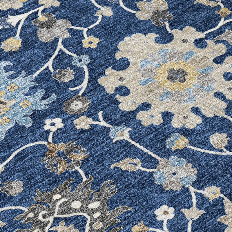 Close-up of navy floral area rug with white, beige, and muted gold motif details