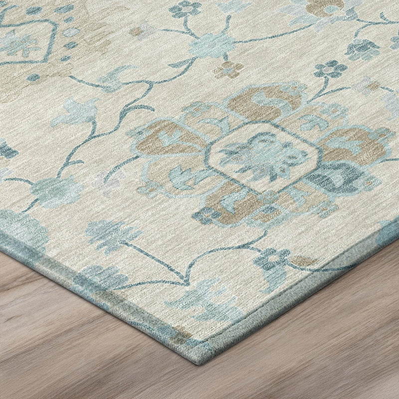 Corner view of round area rug with ivory ground and blue distressed floral vine motif