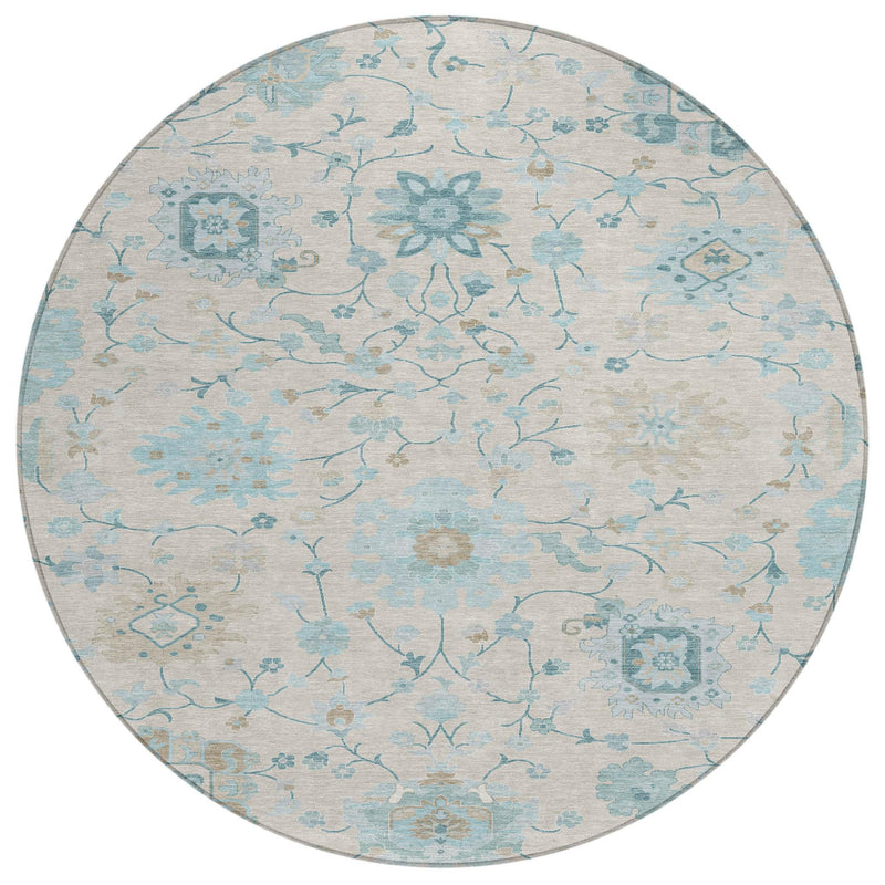 Round area rug showing ivory and blue distressed floral vine design with subtle border