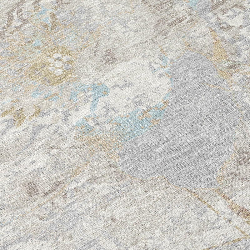 Close-up of ivory and silver area rug with blue and gold abstract details.