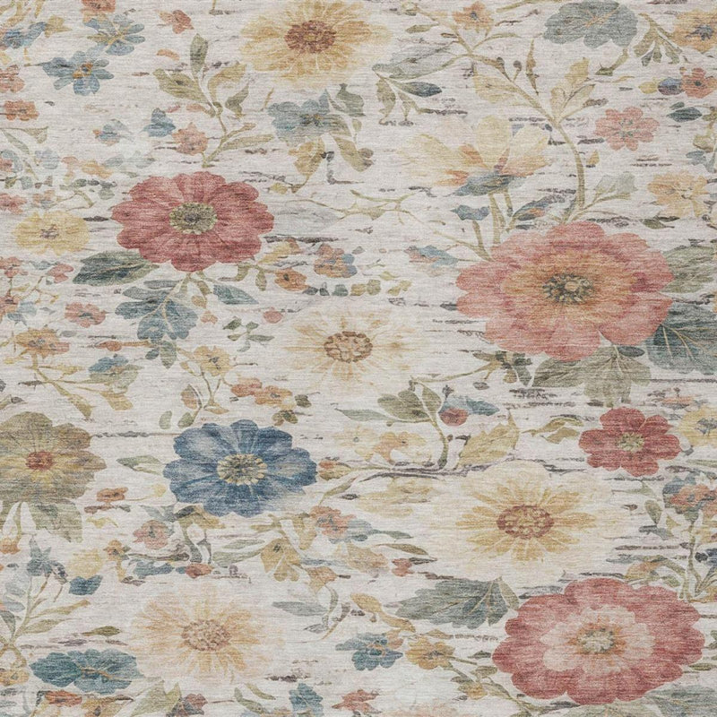 Close-up ivory floral area rug with pink, blue, and gold blossoms on distressed texture