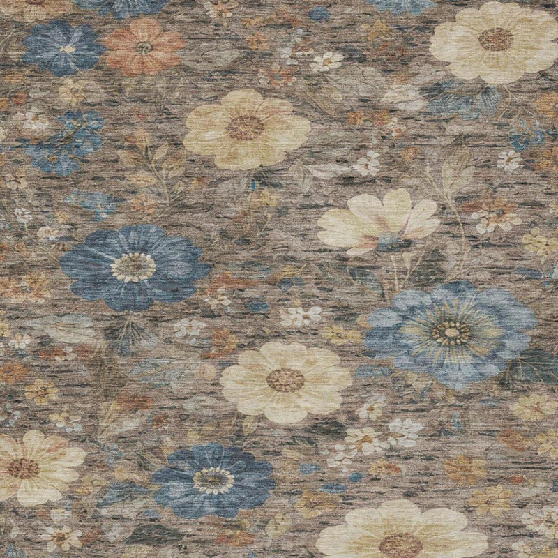 Close-up of distressed floral area rug pattern in blue, cream, and brown on khaki ground