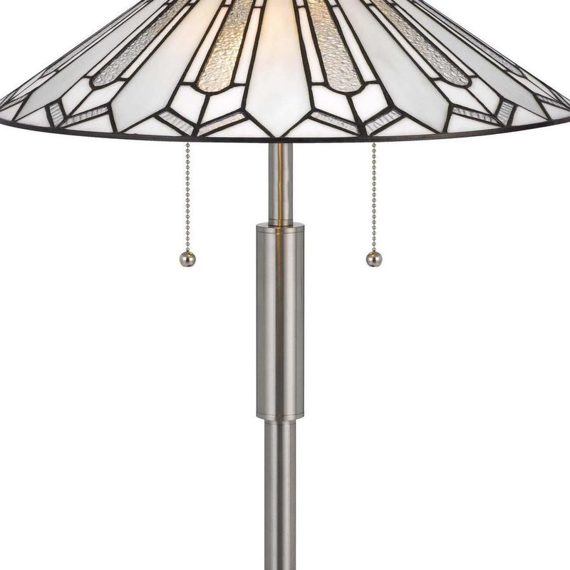 Close view of Tiffany-style lamp shade edge, brass-toned stem, and pull chain drops