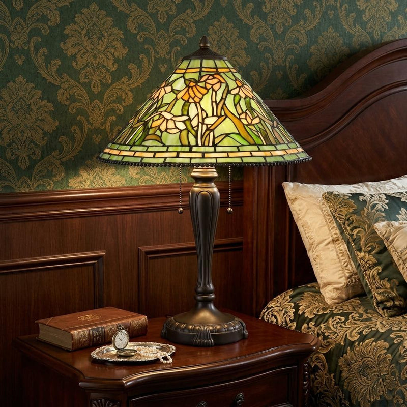 Bronze stained-glass dome table lamp with floral pattern and dark sculpted base