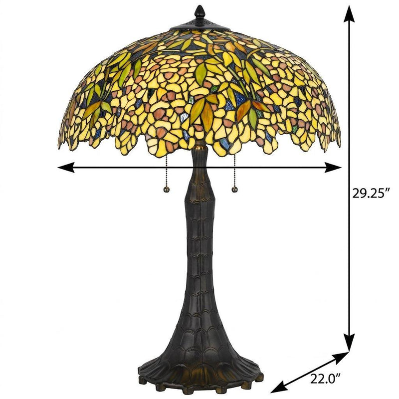 Table lamp with yellow-green stained glass dome shade and tall dark bronze pedestal base