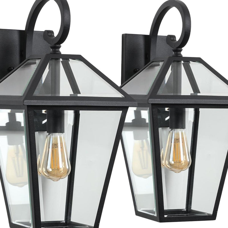 Close-up of black outdoor hanging lantern light with clear panels and exposed filament bulb