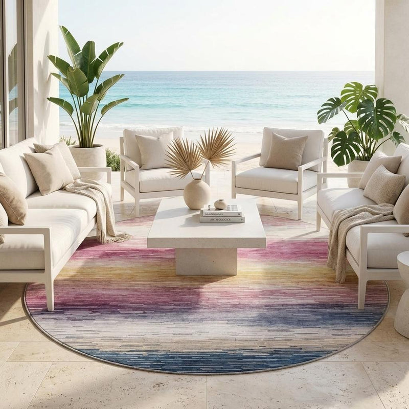 Round striped area rug with blended blush, gold, and blue bands on light flooring