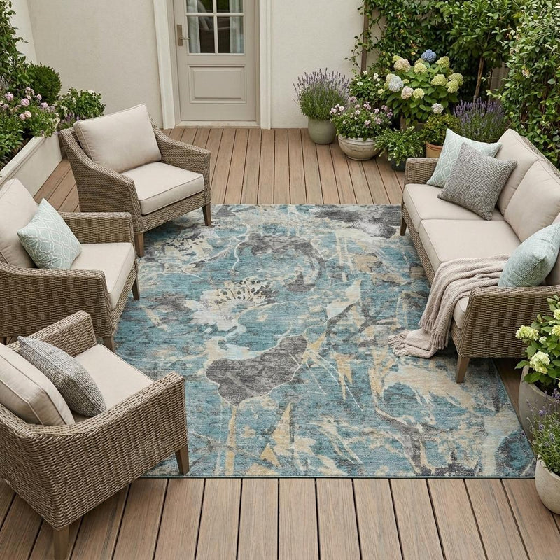 Teal-blue area rug with distressed gray and silver floral pattern in an outdoor seating setup
