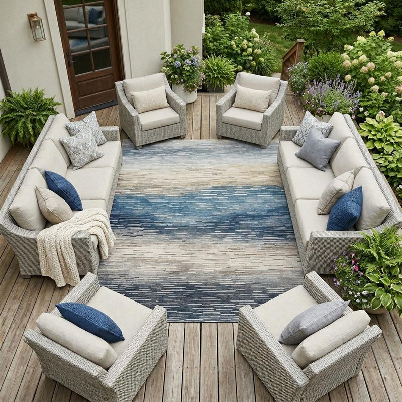 Outdoor seating area rug with blue-and-cream striped pattern on wood deck