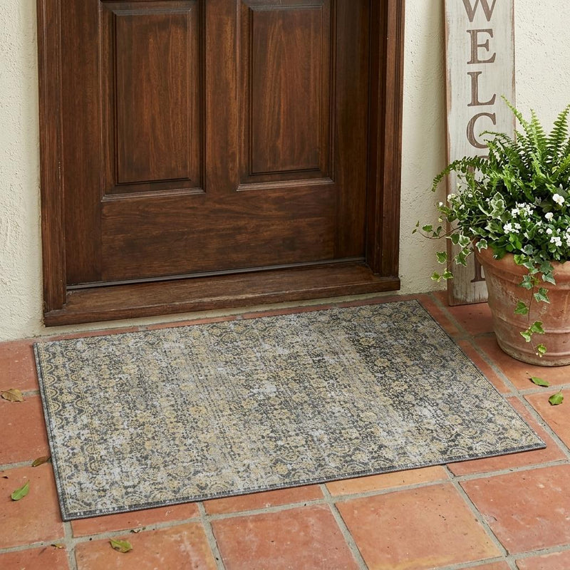 Gray and beige abstract area rug with distressed pattern laid flat on the floor