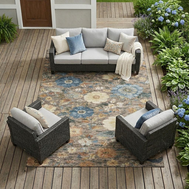 Rectangular floral area rug with blue and cream blooms on distressed tan base.