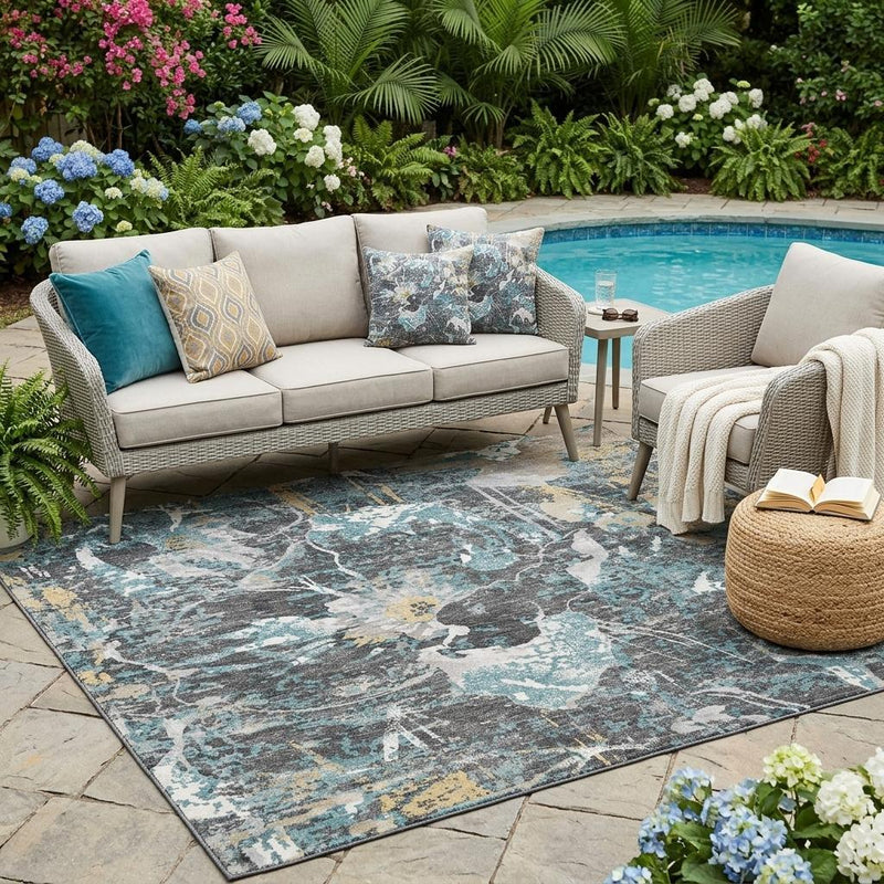 Indoor outdoor area rug with abstract floral pattern in gray, blue, and muted gold