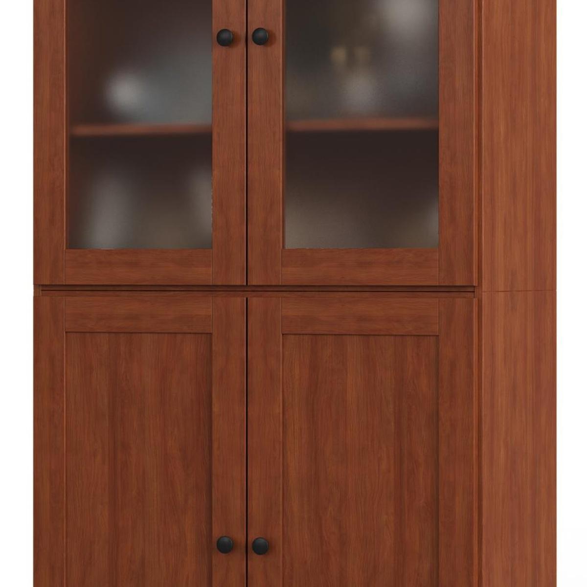 Wood pantry cabinet close-up: glass door frames and two lower doors with knobs