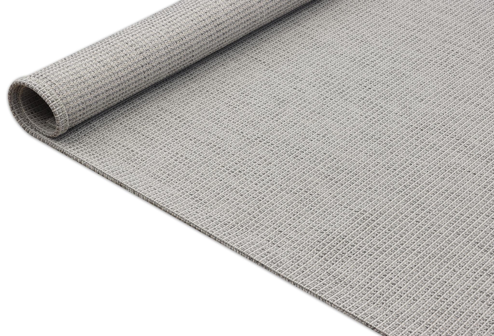 Gray woven area rug with rolled edge showing rug thickness