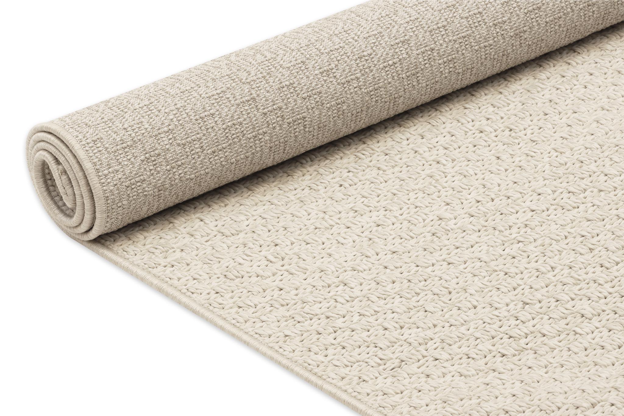 Beige area rug rolled up, showing looped texture and thick flat pile.