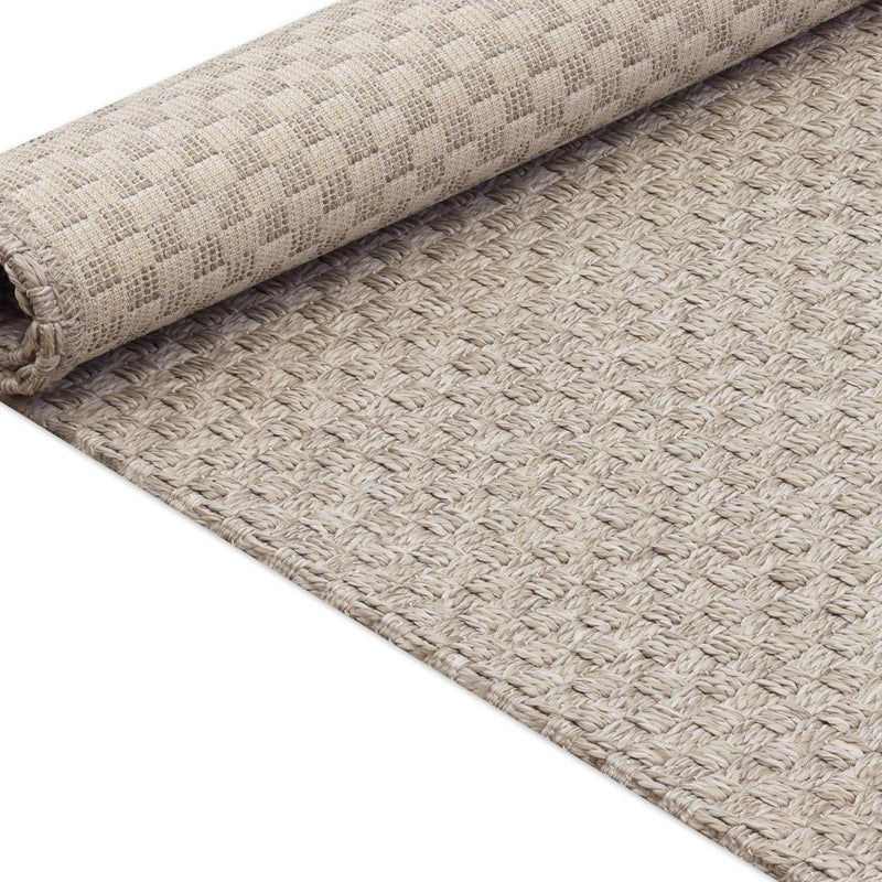 Beige woven area rug with bound edge and textured, looped weave