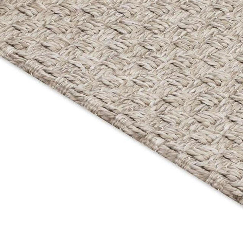 Beige woven area rug with low-profile surface and diagonal weave detail