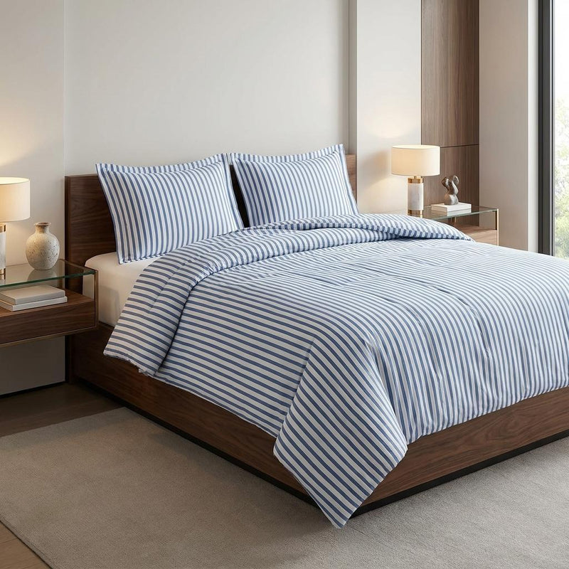 Blue-and-white striped duvet cover with matching shams on a bed