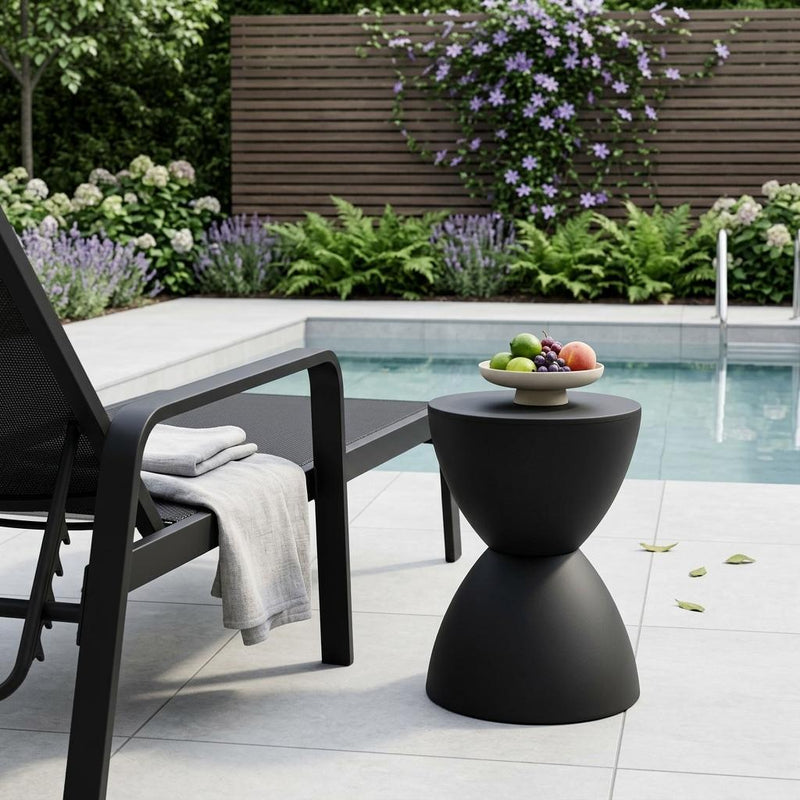 Dark matte black hourglass side table with round top and sculpted pedestal base.