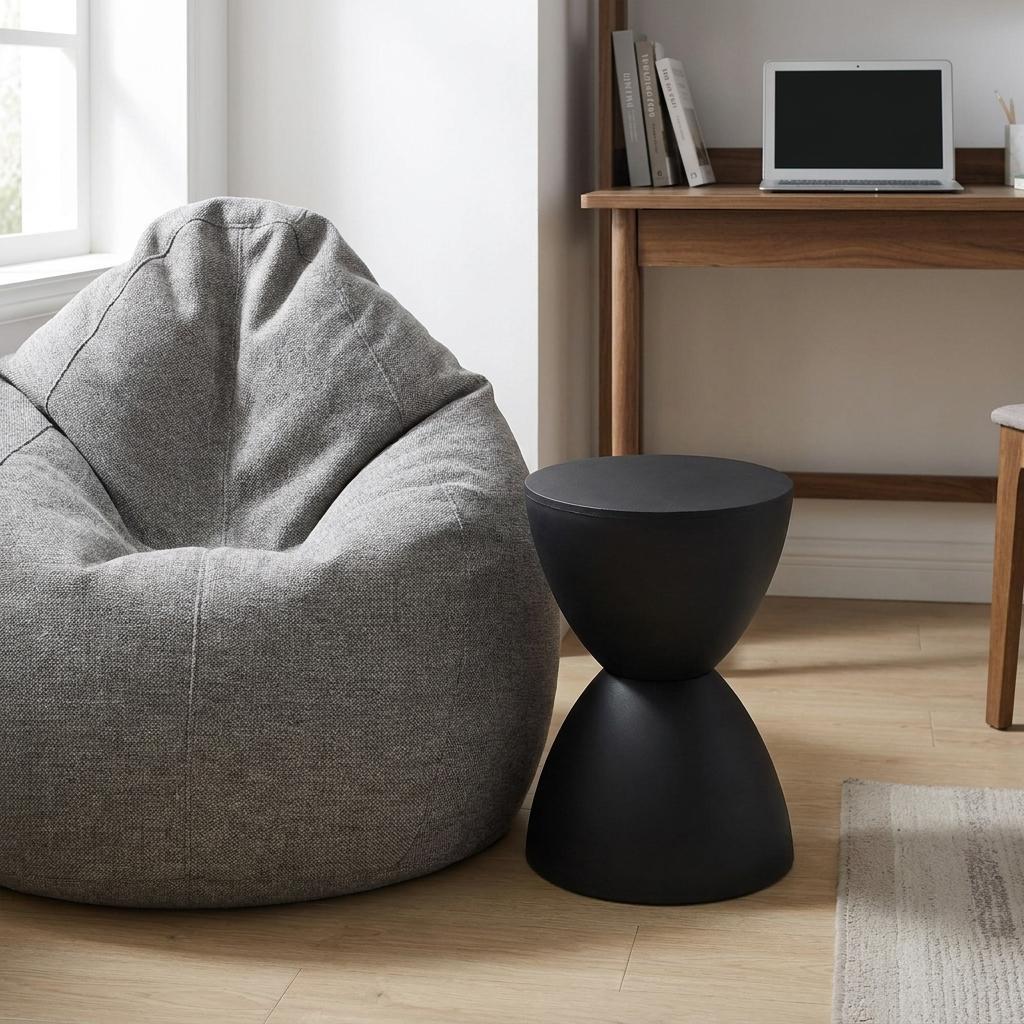 Black hourglass side table, close view of round top and tapered pedestal base.