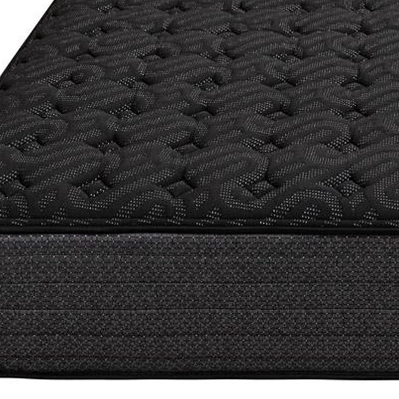 Close-up of dark black quilted mattress surface with small stitched channels.