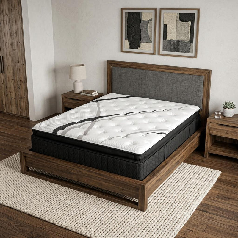 Black hybrid mattress with white quilted top and gray pattern on wooden bed frame