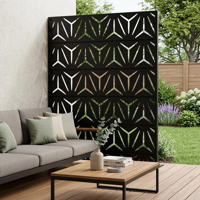 Black outdoor privacy screen with geometric pattern mounted on frame near patio seating