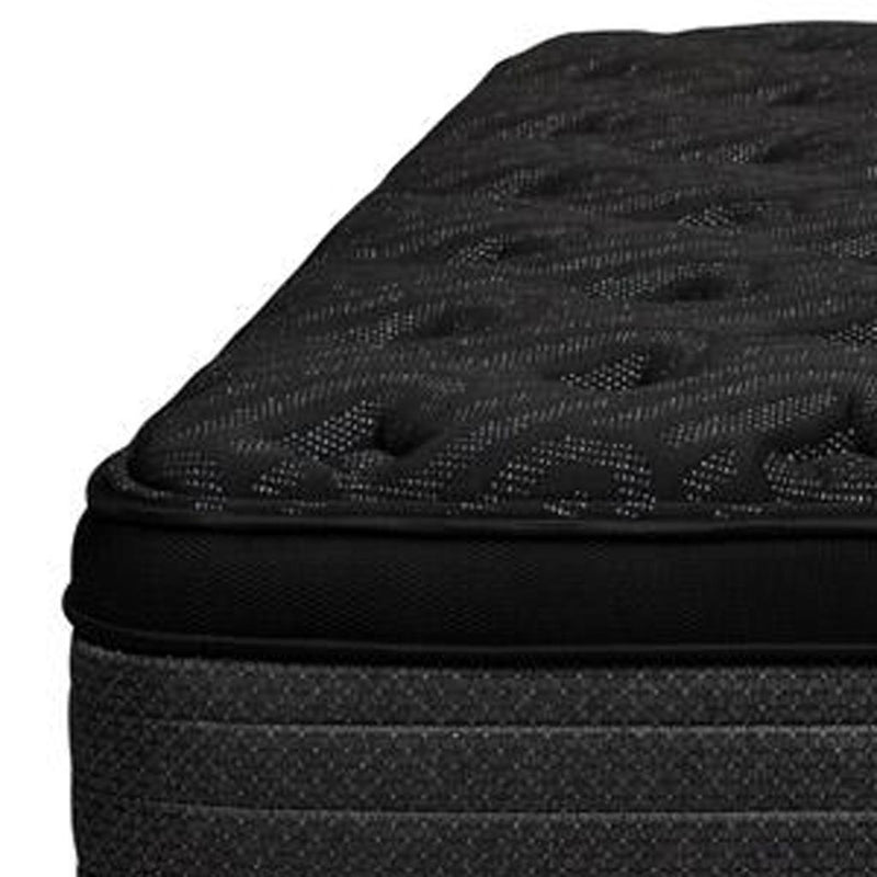 Black mattress edge close-up showing quilted top texture and layered side padding.