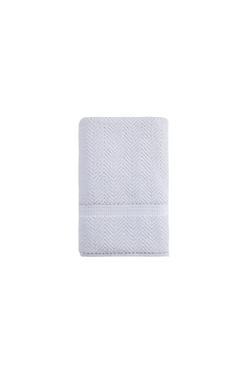 White bath towel folded and rolled, chevron weave texture with stitched edge