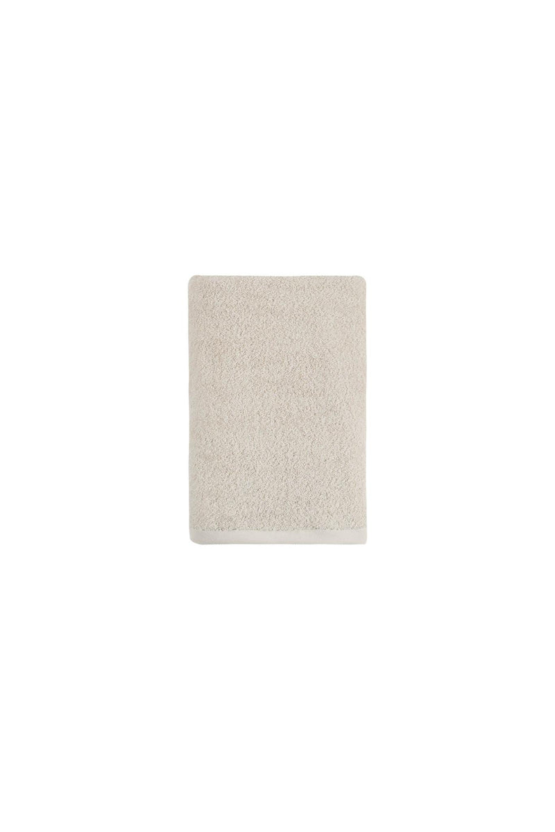 Beige Turkish cotton bath towel, folded towel on plain white background