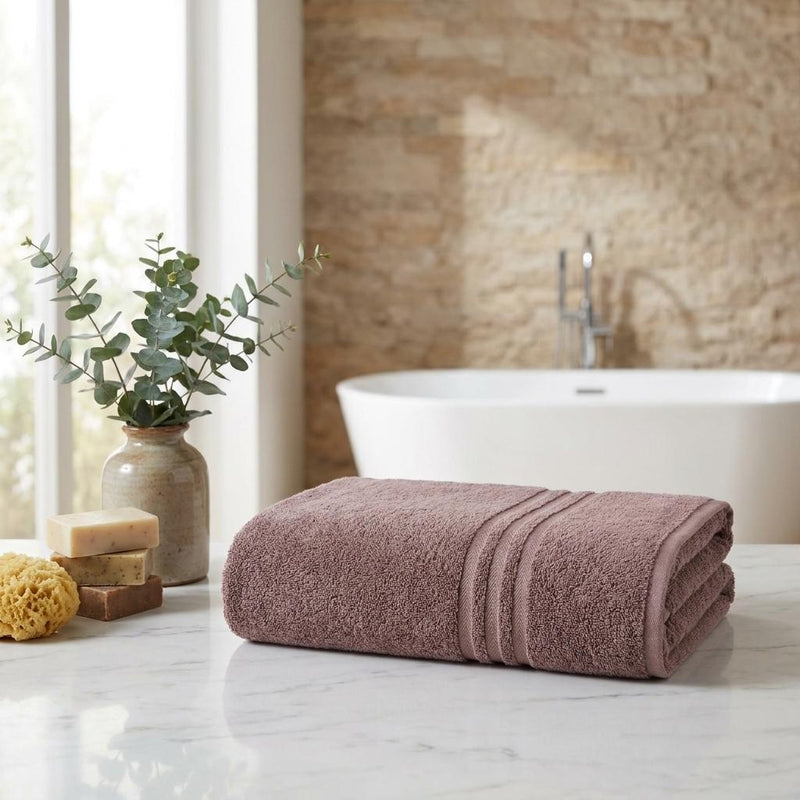 Folded light brown Turkish cotton bath sheet with two horizontal bands and terry texture