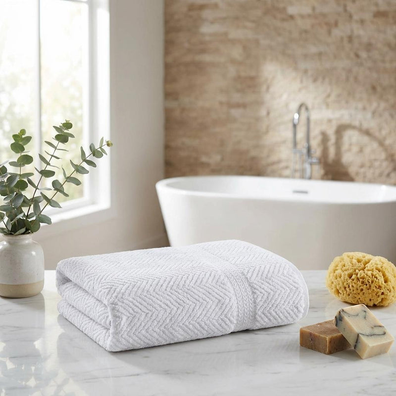 Folded white bath towel with chevron weave texture
