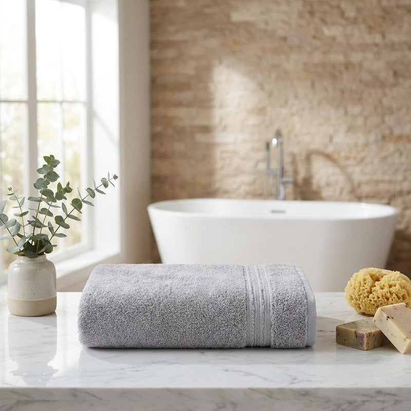 Light gray Turkish cotton bath towel rolled with textured terry and fringed border, 27 x 54 in