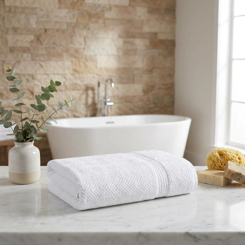 White chevron bath towel, neatly folded with textured surface and stitched edge.