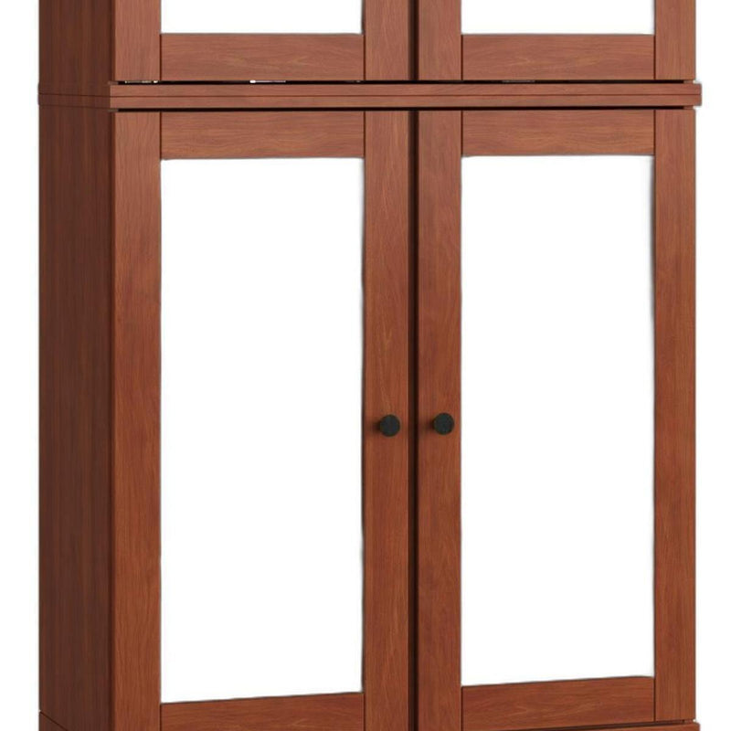 Wood cabinet doors with black knobs and clear glass panels over inner shelves.