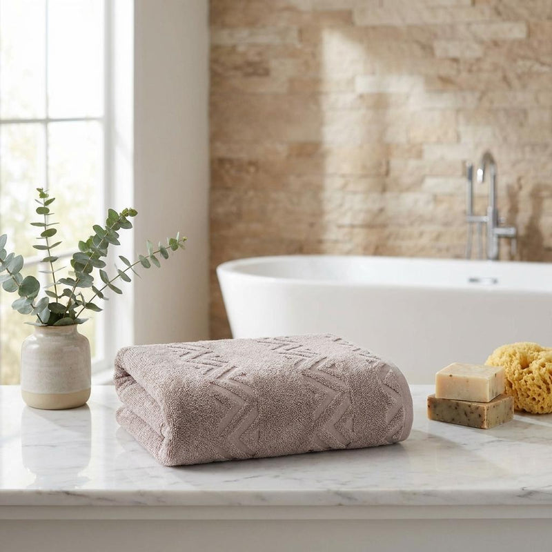 Light brown folded bath sheet with raised chevron jacquard pattern