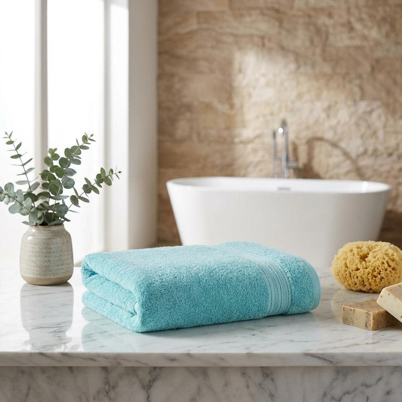 Folded aqua bath towel with terry loop texture, neatly stacked