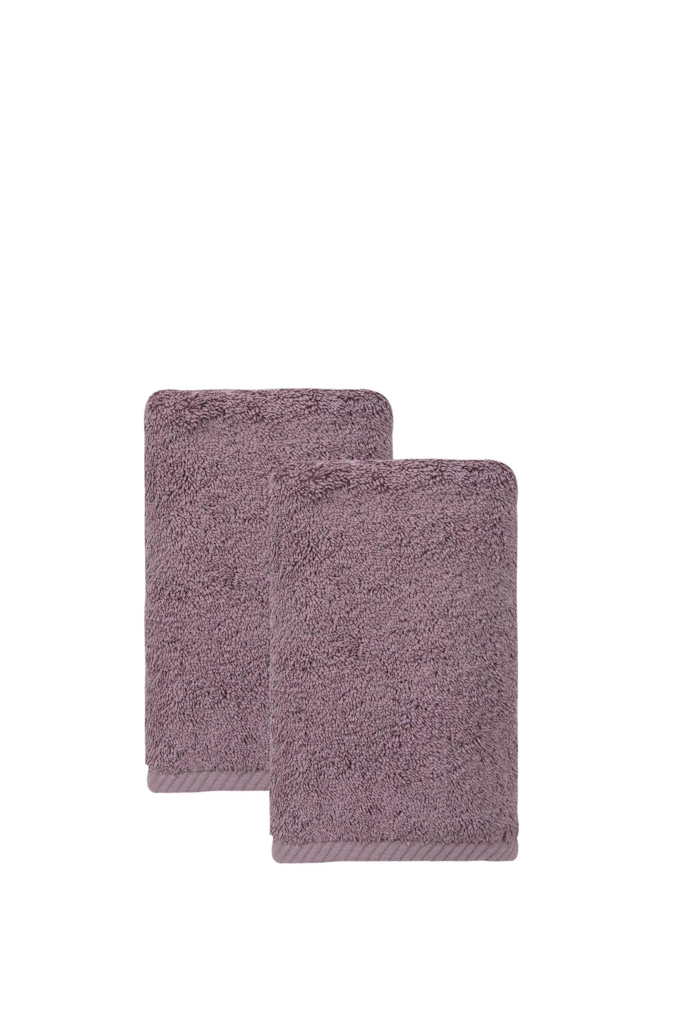 Set of two purple hand towels, folded stack with terry loop texture