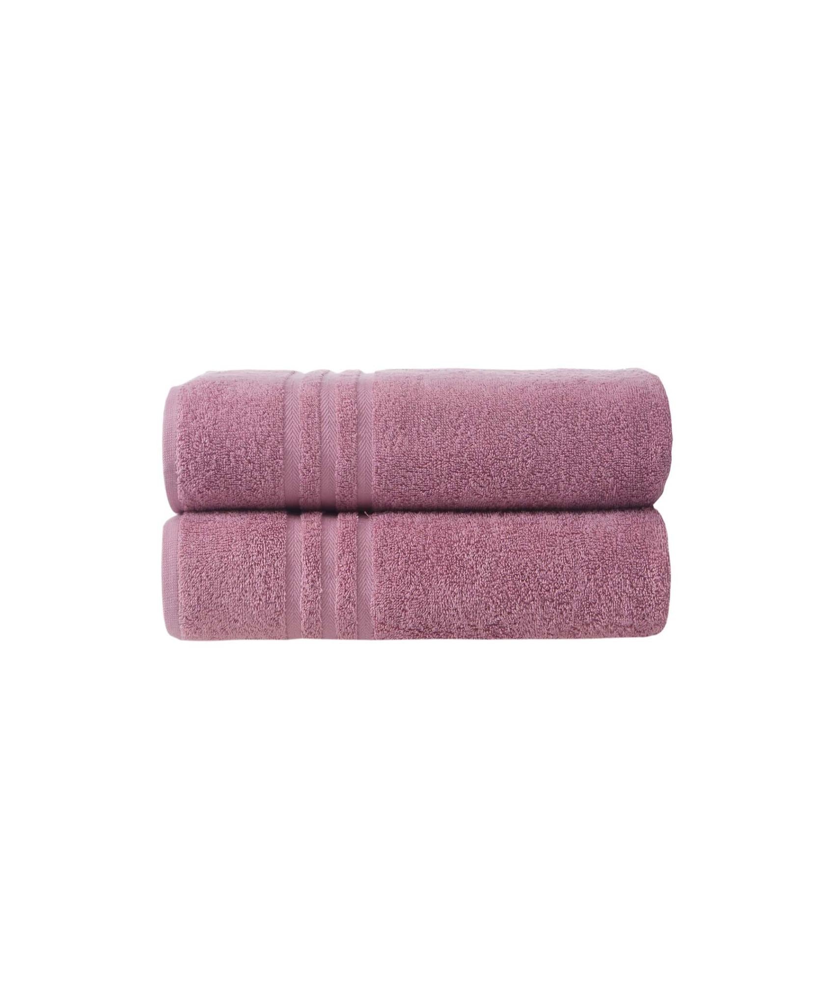 Set of two pink Turkish cotton bath towels, neatly rolled and stacked.