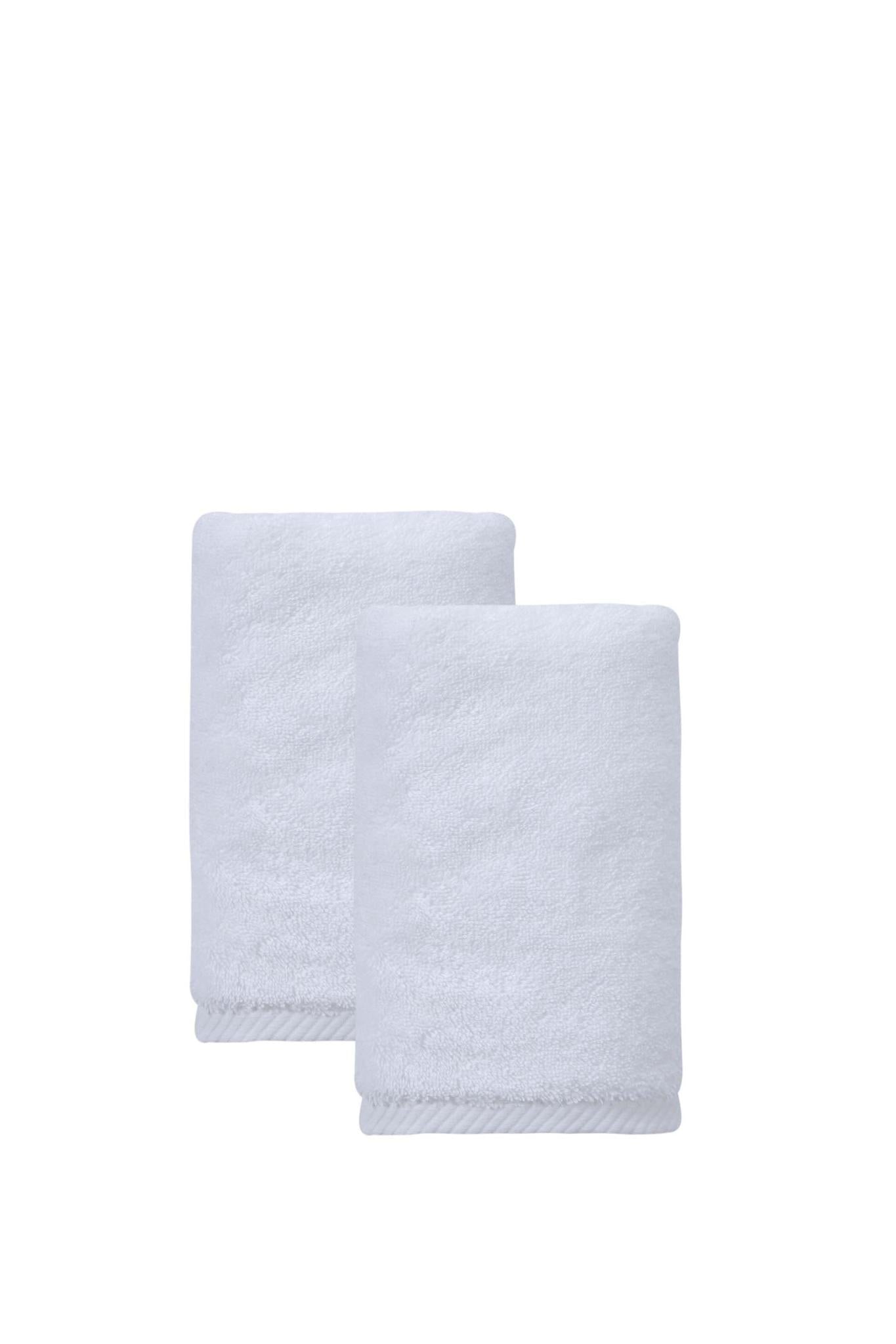 Set of two white hand towels, one towel overlapping another, soft cotton texture