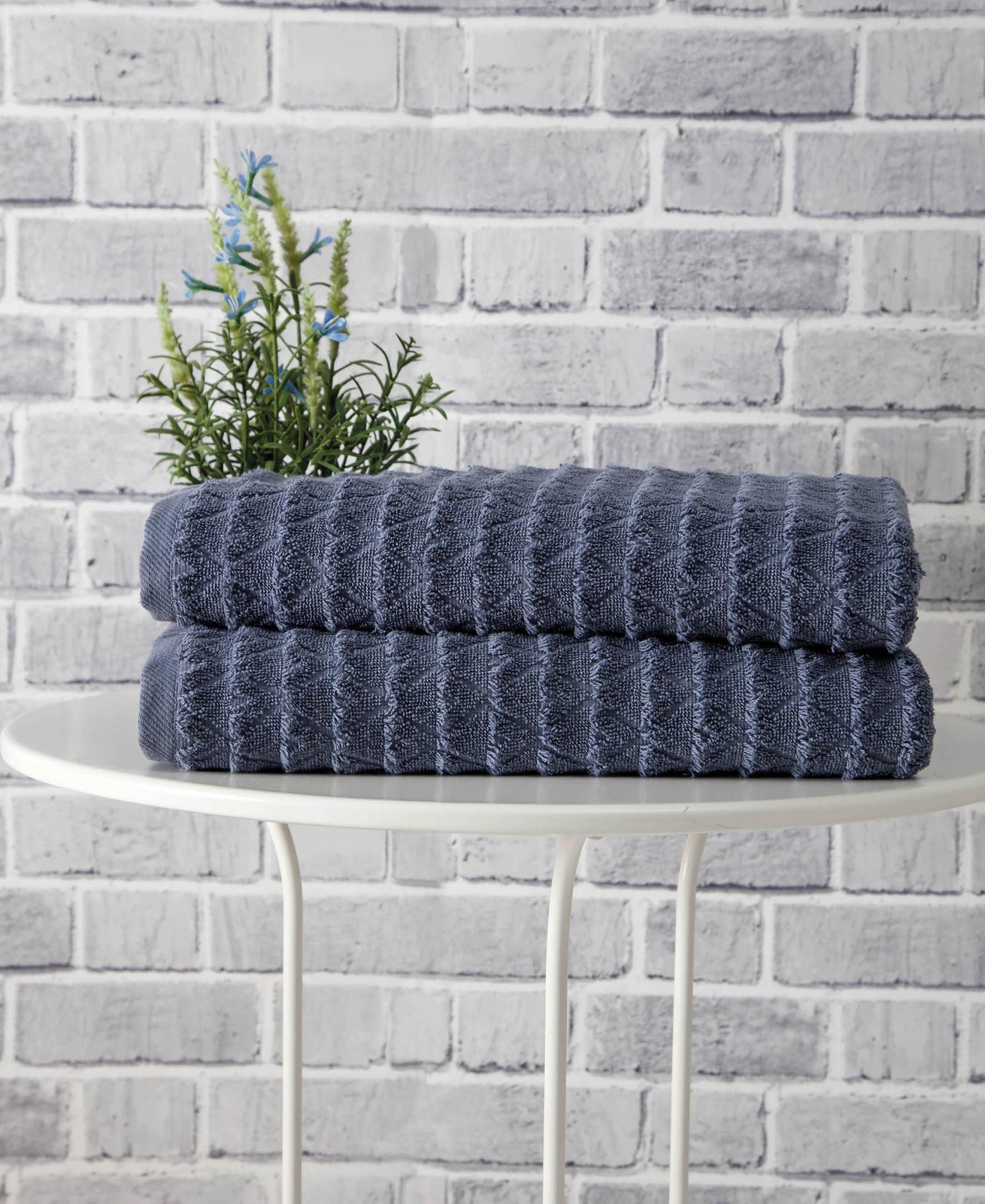 Set of two navy geometric bath towels, Turkish cotton texture; folded stack